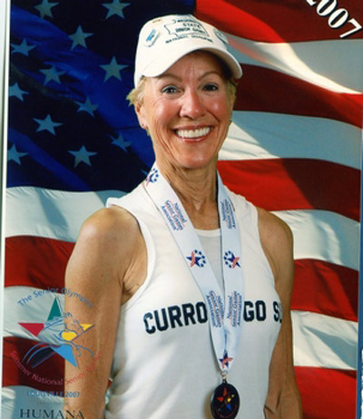 Woman with medal in front of American flag, a patient at Karl Hoffman Dentistry in Lacey, WA